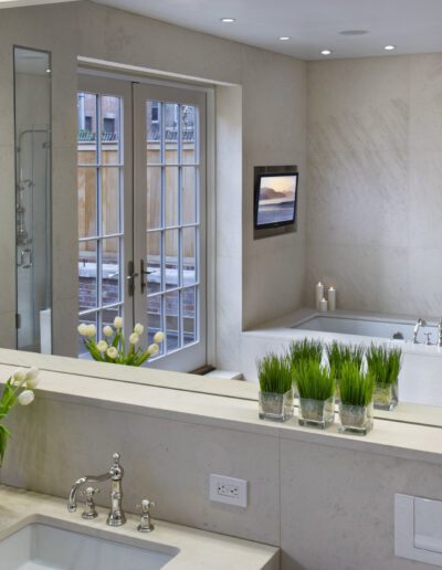 Modern bathroom with dual sinks, large mirror, and walk-in shower enclosure.