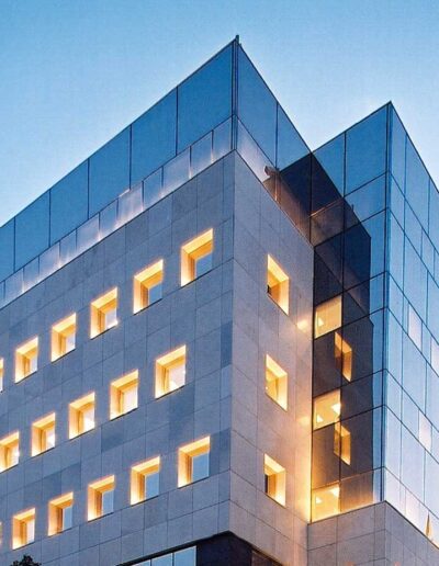 Modern office building at dusk with interior lights on.