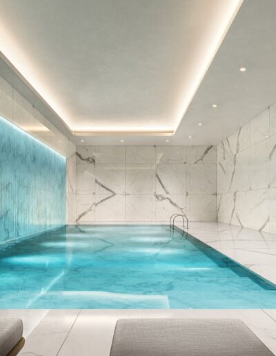 Modern indoor swimming pool with marble walls and blue accent lighting.